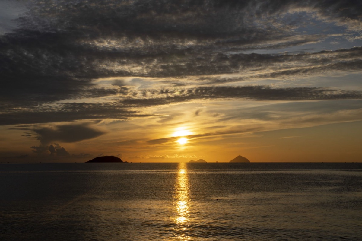 okinawan island sunset with traditional houses in distance